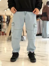 Pantalón cargo de jean azul con múltiples bolsillos en los laterales y diseño holgado.