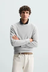 Sweater de punto color beige con textura tipo waffle, cuello redondo y mangas largas con acabado en rib.