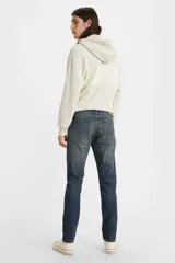 Pantalón de jean azul oscuro, de corte skinny, con tiro medio y ajuste ceñido en muslos y piernas.