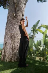 Musculosa negra de lino y rayón con escote alto y laterales abiertos con tiras ajustables.