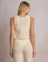 Top crop de tejido calado marrón, marca Elan, con escote redondo, sin mangas y aberturas laterales con lazos ajustables decorados con caracoles.
