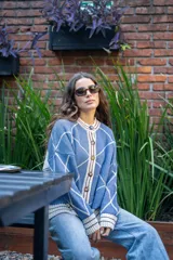 Saco tejido de punto con diseño geométrico de rombos en color azul y blanco. Presenta cuello redondo, cierre frontal con botones, mangas largas abullonadas y terminaciones acanaladas en puños y ruedo.