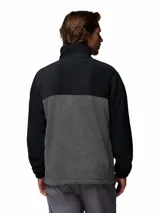Campera polar de Columbia con cierre frontal completo, cuello alto y diseño de bloques de color en negro y gris. Cuenta con bolsillos laterales con cierre y logo de la marca bordado en el pecho.