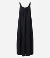 Vestido largo color crema, de corte holgado con frunce en el busto y un gran recorte horizontal en la parte inferior. Posee breteles finos ajustables y escote redondo.