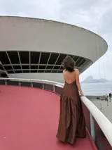 Vestido largo marrón de crepe texturizado, con cuello halter fruncido, diseño holgado y falda larga con vuelo.