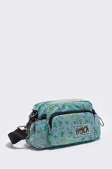 Bolso bandolera de nylon con estampado floral en tonos celeste, verde y amarillo. Tiene asa bandolera ajustable con logo de la marca, cierre de cremallera, bolsillo interior plano y logo en el exterior.