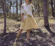 Vestido acampanado color amarillo con estampado de hojas en la parte superior, bolsillos laterales y teñido natural.