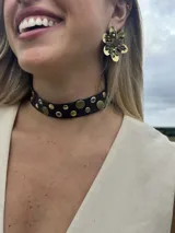Choker de cuero negro con apliques metálicos redondos en tonos plateados y dorados/bronce.