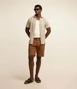 Bermuda masculina de sarga color rosa, corte slim, con bolsillos laterales y cierre con botón y cremallera.