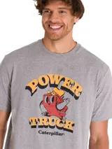 Remera de hombre gris melange con diseño gráfico retro de Caterpillar en el pecho que incluye texto y un personaje animado.