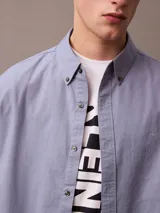 Remera blanca de algodón con estampado vertical en el frente con el logo de Calvin Klein Jeans en letras negras. Corte clásico y cuello redondo.