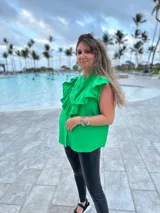 Camisa verde brillante de muselina con volados en el frente y tachas plateadas.