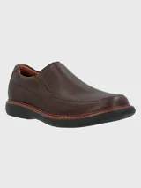 Zapato tipo mocasín Hush Puppies modelo Oregon, confeccionado en cuero vacuno con textura granulada. Presenta un diseño sin cordones con elásticos laterales para un ajuste cómodo, costuras reforzadas y suela de goma EVA de alto rendimiento.