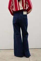 Pantalón de denim tiro alto con corte oxford y tajos laterales en el ruedo. Presenta cierre frontal con botones a la vista y costuras verticales decorativas.