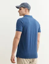 Remera polo azul marino con estampado de pequeños puntos blancos, cuello clásico con tres botones y mangas cortas.