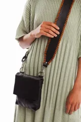 Bandolera negra de cuero vacuno con correa ancha trenzada a mano. Tiene forro interior y cierre con broche imán en la solapa.