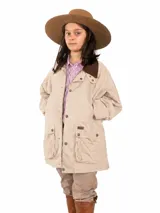 Campera tipo encerada de color beige, con cuello de terciopelo marrón oscuro, cierre frontal con botones a presión y amplios bolsillos frontales con solapa.