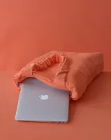 Bolso tipo totebag acolchado color amarillo, con manijas cortas y logo bordado en una esquina. Ideal para transportar una laptop.