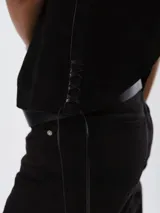 Chaleco de cuero azul marino con corte oversize, diseño sin mangas y laterales ajustables mediante cordones de cuero en tono natural.