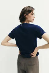 Jersey de punto de cuello redondo y manga corta, con diseño minimalista y textura suave.