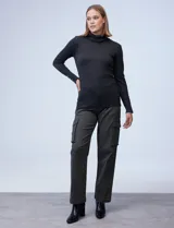 Polera gris de tejido fino con cuello alto y mangas largas con aplique de botones en los puños.