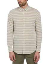 Camisa de hombre de manga larga con rayas horizontales en tonos beige y gris. Tiene cuello abotonado, bolsillo en el pecho y cierre con botones.