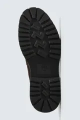 Mocasín de vestir para hombre, confeccionado en piel con acabado de serraje en color marrón oscuro. Presenta un diseño clásico con detalle de antifaz en el empeine, horma redonda y una suela track robusta de goma.