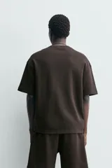 Sudadera de manga corta con corte relajado, confeccionada en tejido interlock de algodón con elasticidad y cuello redondo.