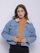 Campera de jean blanca con interior de corderito color beige, dos bolsillos grandes en la parte frontal y siete botones metálicos.