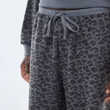 Pantalón de corte ancho con estampado de leopardo en tonos grises, confeccionado en tejido suave, con cintura elástica y cordón ajustable.