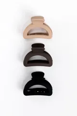 Pack de tres pinzas para el pelo ovaladas en tonos neutros: beige, marrón oscuro y negro, con acabado mate.
