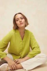 Camisa verde lima de manga larga con cuello mao y escote en V. Cuenta con botones forrados en la misma tela y puños elásticos.