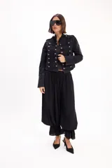 Pantalón negro de corte amplio, con cintura elástica fruncida y diseño abombacho con volados en los tobillos.