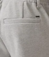 Pantalón de corte slim color gris claro, confeccionado en tejido de poliéster con mezcla de algodón y elastano. Presenta cintura elástica con trabillas, cierre frontal con botón y cremallera, y bolsillos laterales y traseros.