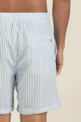 Short de baño celeste con rayas verticales blancas y logo bordado en negro en la pierna derecha.