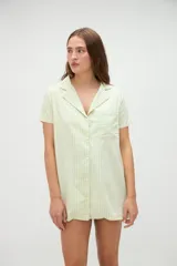 Vestido camisero de algodón con diseño a rayas verticales en tono amarillo claro, cuello solapa y cierre frontal de botones.