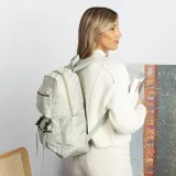 Mochila de gran capacidad color beige, confeccionada en nylon. Cuenta con múltiples compartimentos frontales con cierre y hebillas ajustables, bolsillos laterales y correas acolchadas para mayor comodidad.