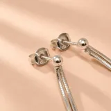 Caravanas colgantes de plata con doble cadena y cuentas cilíndricas de resina color turquesa y cuentas plateadas.