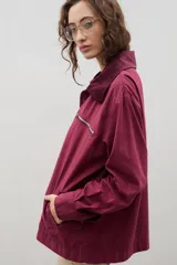 Campera de jean azul oscuro con cuello de pana en color crema. Presenta cierre frontal metálico, bolsillo con cierre en el pecho y bolsillos laterales. Diseño de corte holgado con mangas largas.