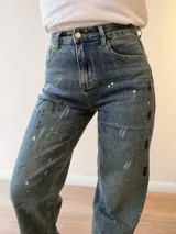 Jeans mom fit de tiro alto y pierna relajada, en tono denim envejecido con matices gris-azulados. Presenta un diseño exclusivo con efecto de pinceladas y salpicaduras artísticas, bolsillos delanteros y traseros, y costuras reforzadas.