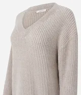 Suéter de punto color beige con escote en V, mangas largas con puños ajustados y diseño holgado. Confeccionado en poliéster.