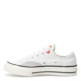Championes de lona Converse modelo Chuck 70, color blanco con detalles en gris claro en los laterales, suela de goma color crema con líneas negras y ojal superior en color rojo.