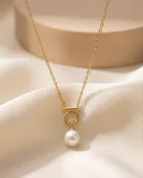 Collar de plata 925 con baño de oro, compuesto por una cadena fina y un dije circular que sostiene una perla natural y una pequeña circonia brillante.