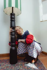 Buzo amarillo con mangas azul marino y puños rojos. Presenta un bordado de una flor en la espalda y un parche con el logo de la marca en el frente.