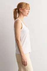Musculosa blanca básica de corte recto, con escote redondo a la base y tirantes anchos.