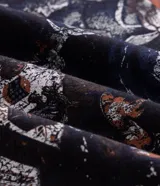 Remera negra de algodón, con cuello redondo, manga corta y estampa frontal temática de gatos.