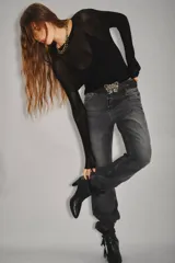 Jean de tiro alto con corte recto, confeccionado en denim rígido de color negro. Presenta un diseño clásico con cierre y botón, bolsillos traseros con bordado de alas y ruedo desarmado.