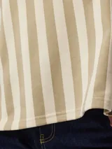 Remera a rayas color beige y blanco, de manga corta, cuello redondo, hombros caídos y calce holgado, confeccionada en tejido de punto rizo.
