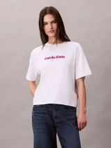 Remera blanca de manga corta Calvin Klein, con cuello redondo, corte regular y logo de la marca bordado en 3D en color fucsia en el pecho.