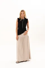 Pollera larga de silueta fluida, con corte a la cadera y frunce que aporta volumen. Confeccionada en tela suave con acabado tipo piel de durazno.